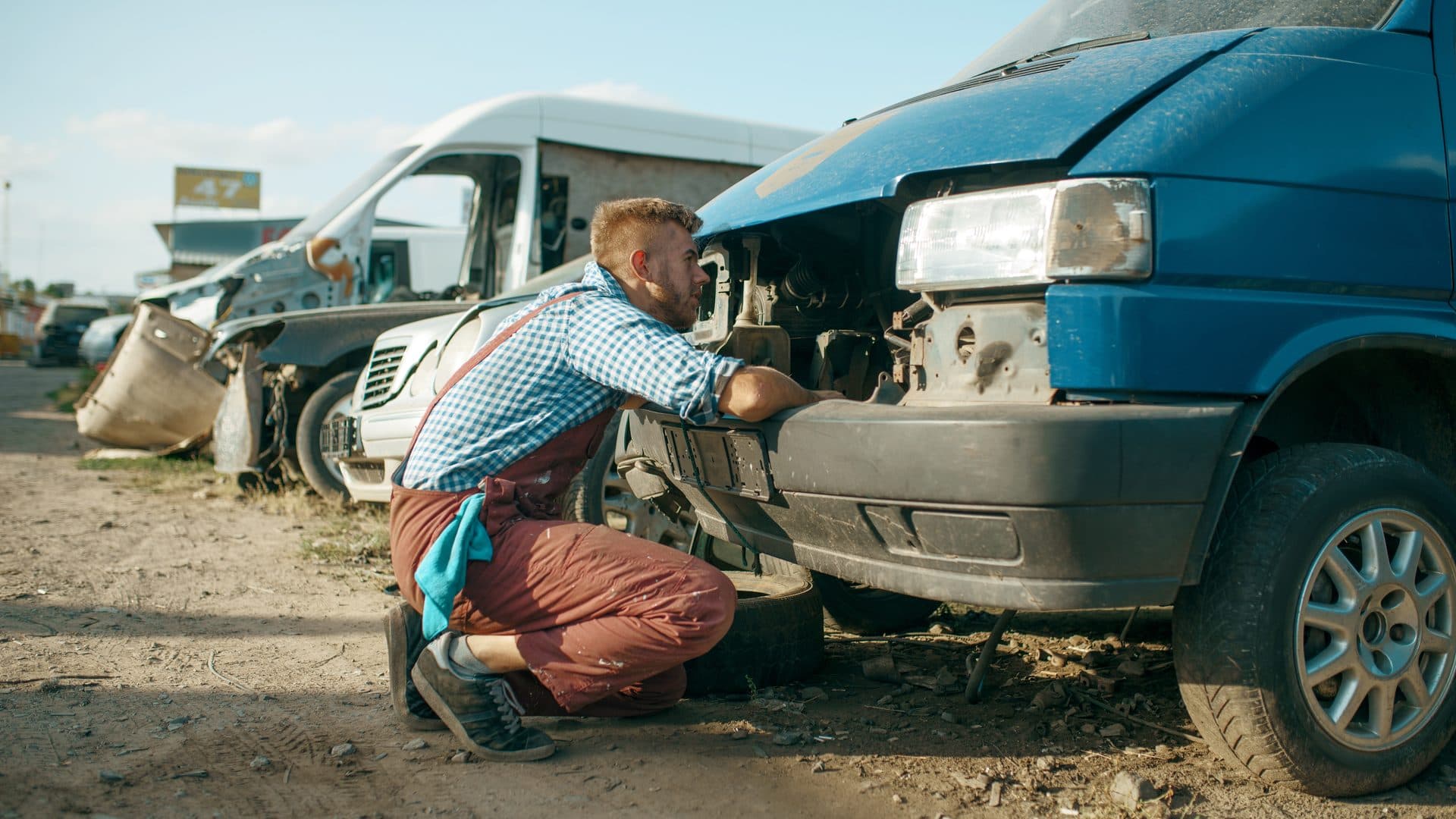 Mobile mechanic working on a car in a driveway after the owner supplied the parts