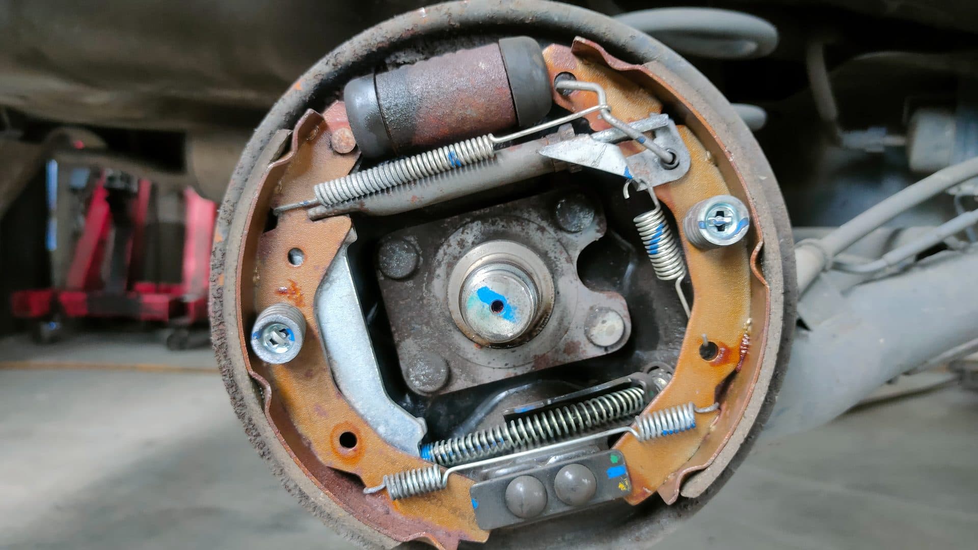 Mobile mechanic working at a car in a driveway during a brake visit